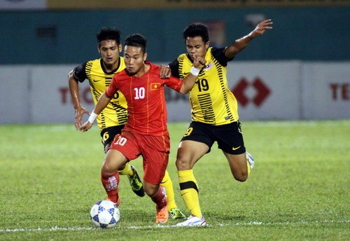 Phi Sơn đi bóng nỗ lực trong vòng vây của các cầu thủ U21 Malaysia....